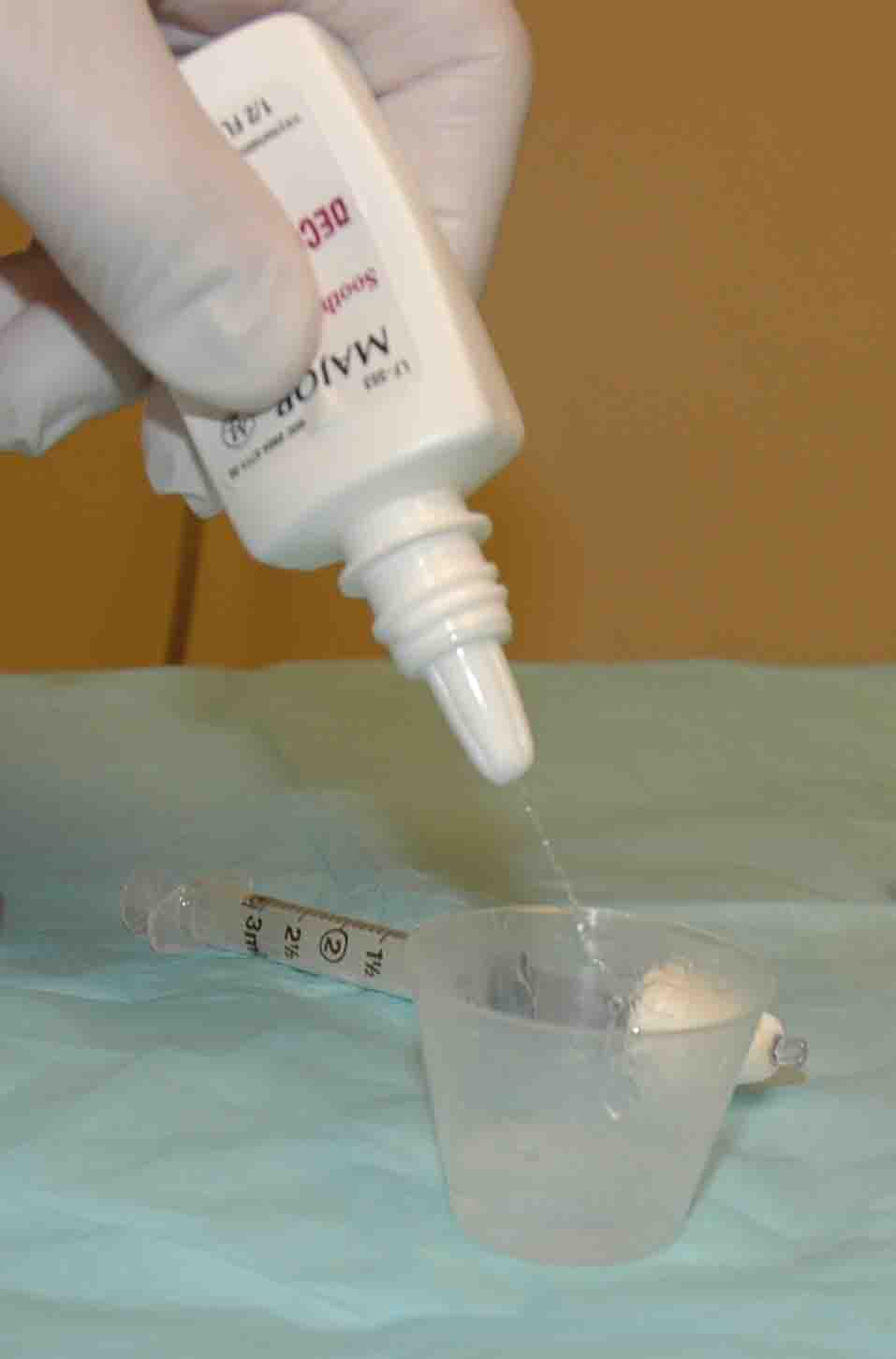 Spray oxymetazoline into a cup to soak cotton ball